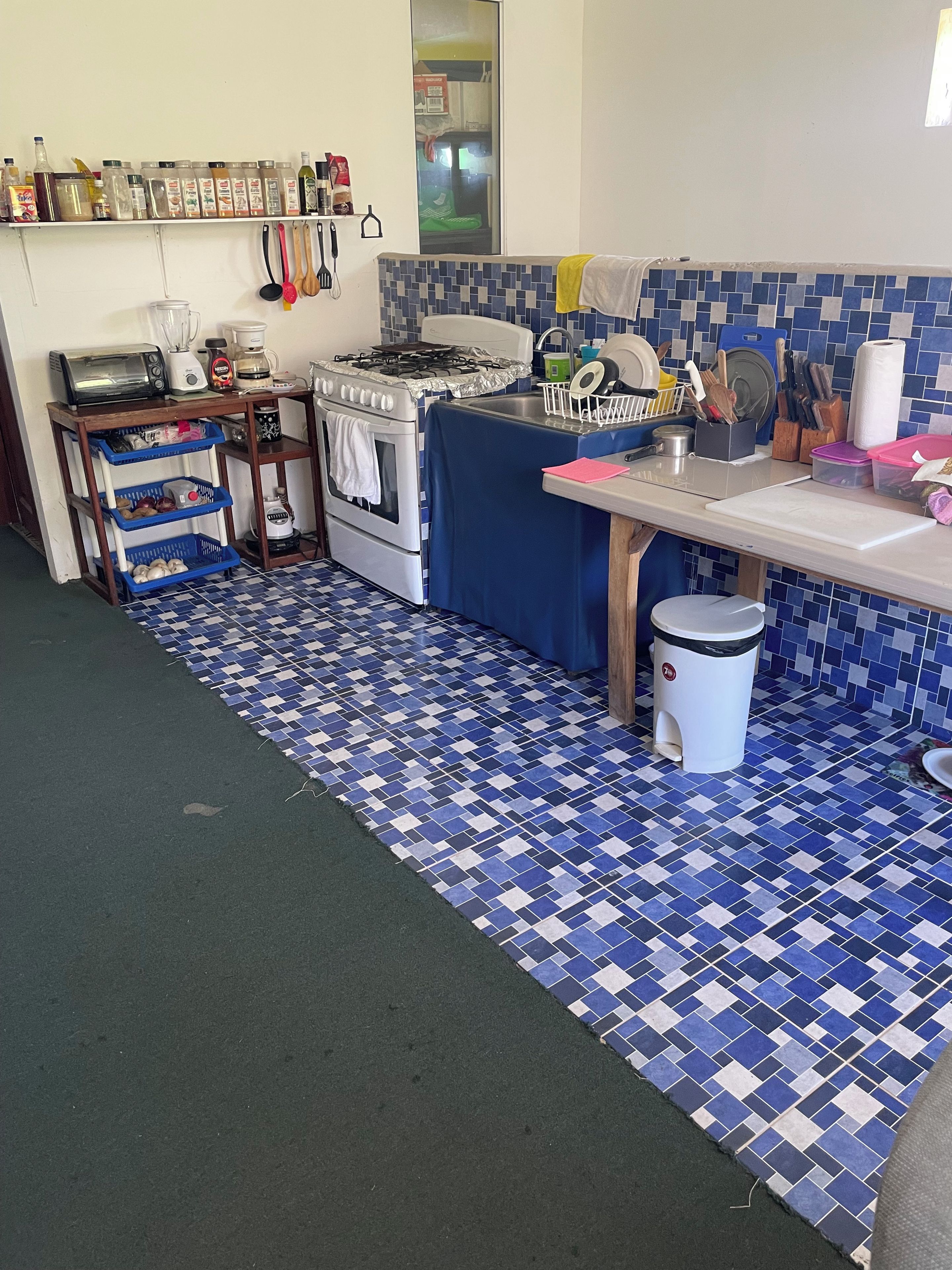 Een keuken met een kookplaat, oven en diverse keukengerei.