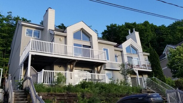 A two-story house with a balcony, a chimney, and a staircase leading to the entrance.