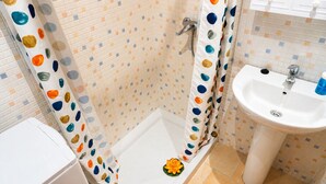 A bathroom with a shower, a sink, and a toilet.