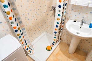 A bathroom with a shower, a sink, and a toilet.