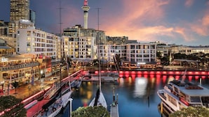 A waterfront hotel with multiple floors, a prominent tower, and a marina with boats.