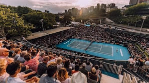 A tennis court surrounded by a crowd of spectators.