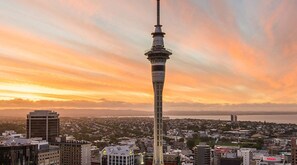 A cityscape with a prominent tower, likely a telecommunications tower, amidst urban buildings. - Spacious 3-Bed Waterfront Apartment (Auckland)