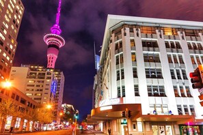 A cityscape with a prominent tower, modern buildings, and a traffic light. - Downtown Charm in Storied Heritage Building (Auckland)