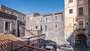 Una calle estrecha flanqueada por edificios, con balcones y un pequeño arco.