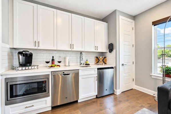 A modern kitchen with white cabinetry, stainless steel appliances, and a window providing natural light. - Prime Luxury: New Townhouse in Tampa's Best Spot! (Tampa)