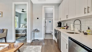 Una cocina moderna con armarios blancos, electrodomésticos de acero inoxidable y lavavajillas integrado.