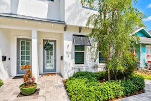 A two-story house with a front door, a mailbox, and a number '1314' on the wall.