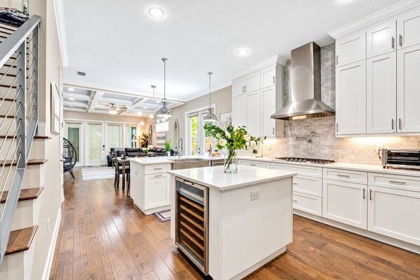 A modern kitchen with white cabinetry, a central island, and a built-in oven.