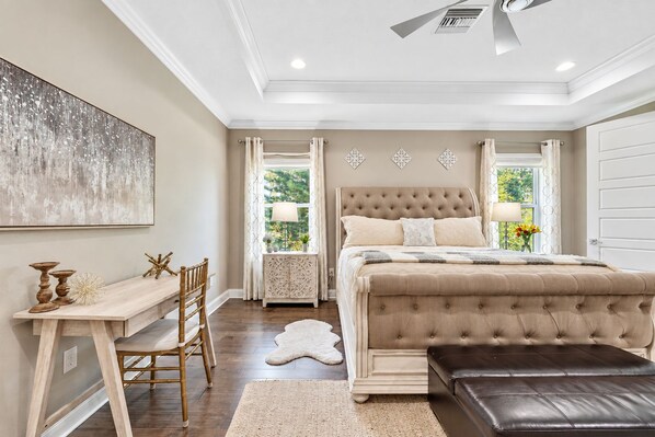 A bedroom with a large bed, a desk, and a chair.