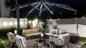 Un espacio al aire libre con patio, un sofá, sillas y una mesa baja.