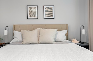 Ein Schlafzimmer mit einem großen Bett, zwei Nachttischen und zwei Wandlampen.