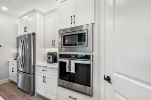 Eine moderne Küche mit Edelstahlgeräten, darunter ein Kühlschrank, eine Mikrowelle und ein Backofen.