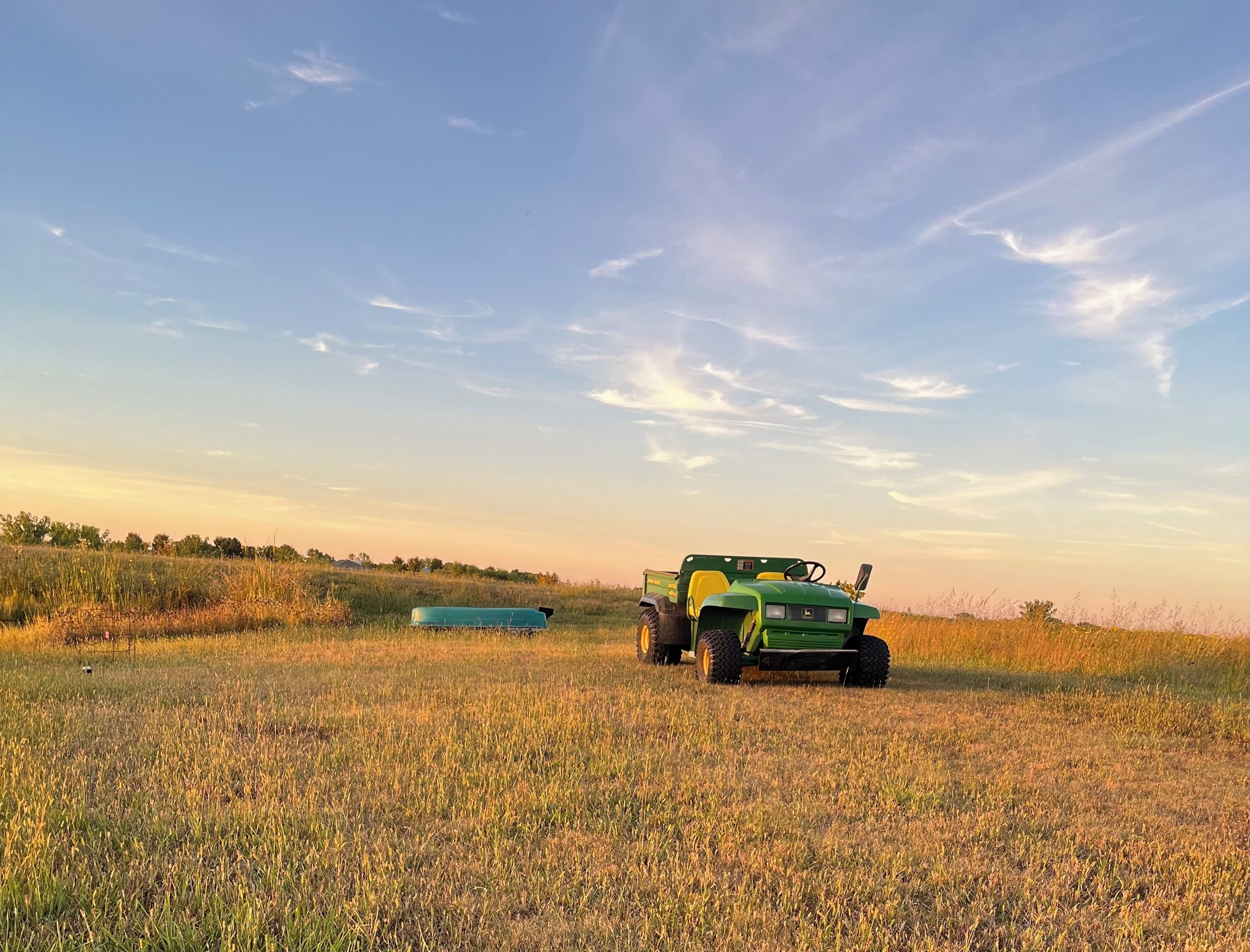 Un tractor verde en un campo con cielo despejado.