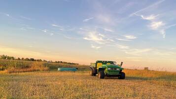 Un tractor verde en un campo con cielo despejado.