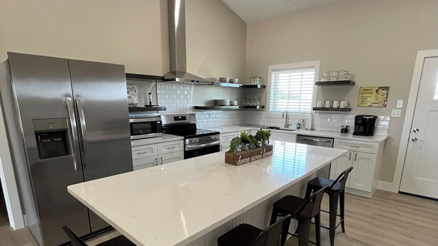 A modern kitchen with a large island, stainless steel appliances, and a clean, minimalist design.