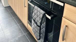 Une cuisine moderne avec des carreaux noirs et blancs, des appareils électroménagers en acier inoxydable et des armoires en bois.