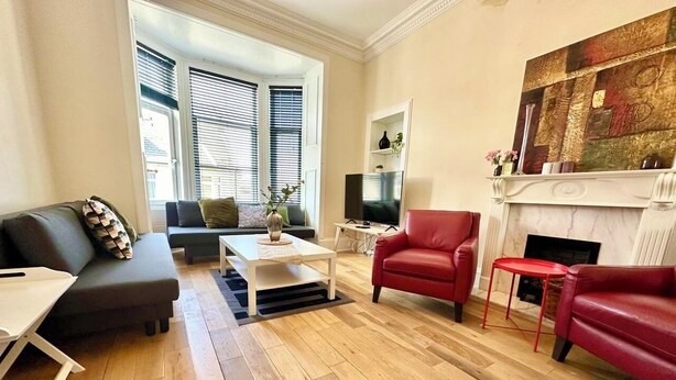 Un salon comprenant un canapé, un fauteuil, une table basse et une cheminée.