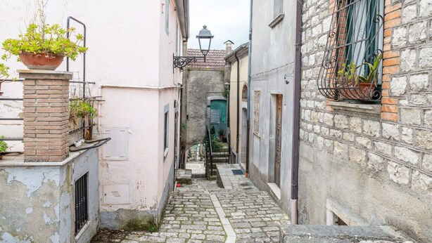 A narrow cobblestone alleyway between buildings with a brick staircase leading to a door. - Sant'Janni - Buonalbergo (Buonalbergo)