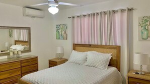 A bedroom with a bed, wooden nightstands, a dresser, a ceiling fan, and a window with curtains. - Comfort & Relax! (El Dorado)