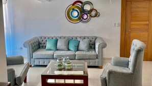 A living room with a grey sofa, two armchairs, a coffee table, and a chandelier. - Comfort & Relax! (El Dorado)