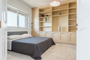 Una camera da letto con un letto, una finestra, un armadio a muro e un comodino.