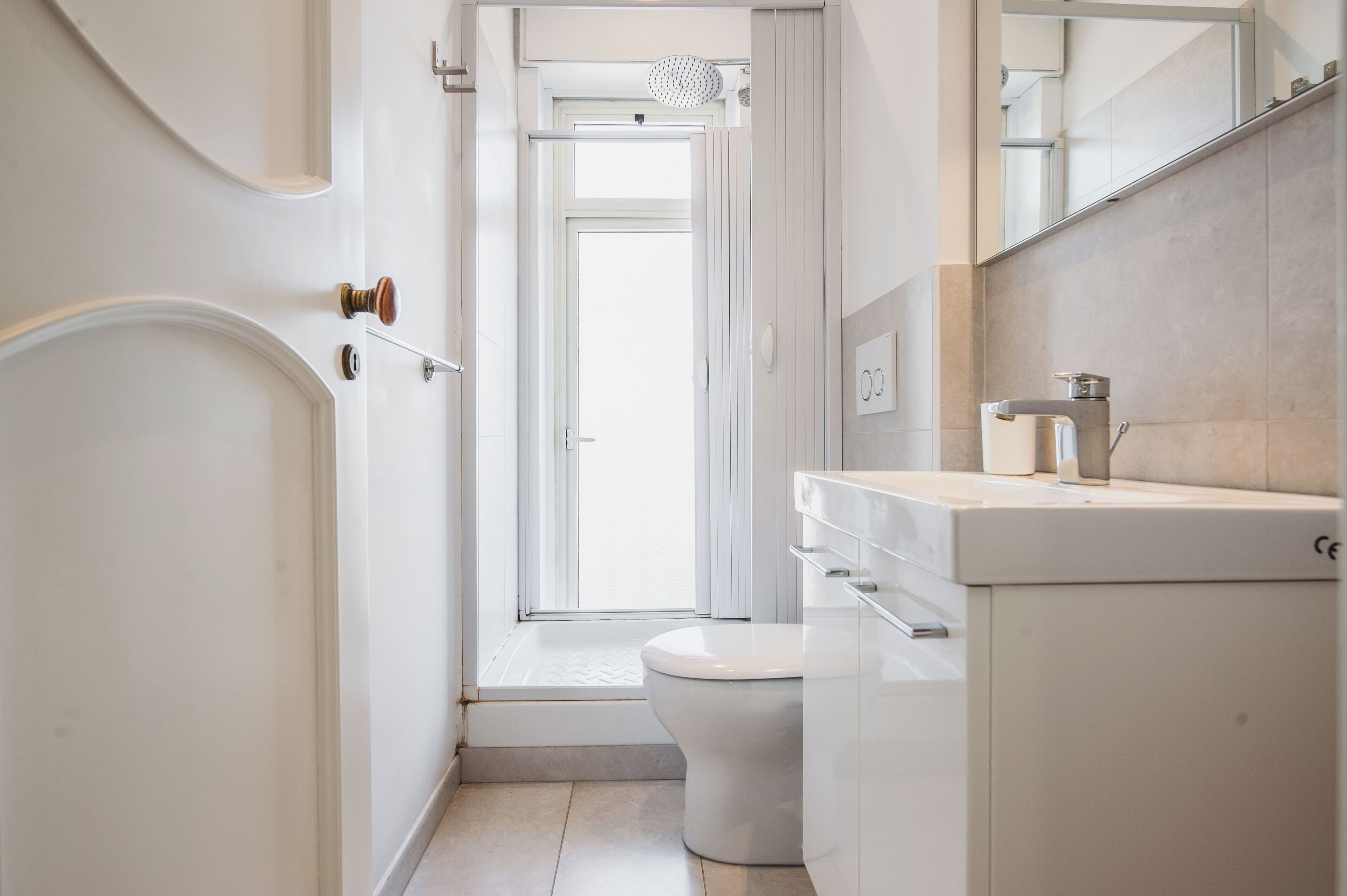 A modern bathroom with a toilet, sink, and shower.
