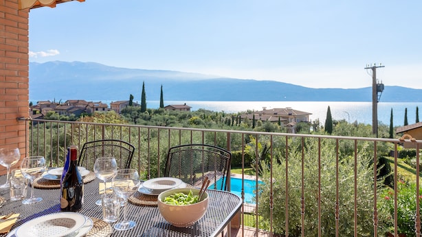 A table set for dining with a view of a lake and mountains.