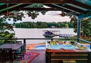 A hot tub with a view of a lake and dock.