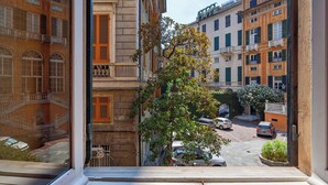 A view from a window overlooking a street with parked cars and buildings with balconies. - La finestra sul cortile di Via Roma by Wonderful Italy (Genoa)