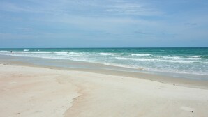 A beach with a sandy shore and waves.