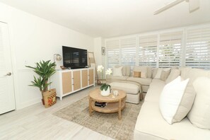 Relax in this stylish living room with a large TV, comfortable sofa, and cozy coffee table.