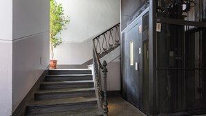A staircase with a wrought iron railing leading to a door with a metal mesh. - Casa Juliette by Wonderful Italy (Turin)