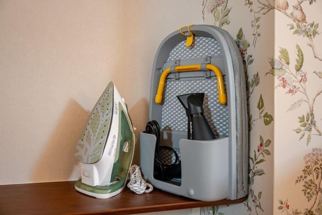 A wall-mounted ironing board with an iron and a steam iron.