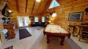 A wooden interior with a pool table, a sofa, and a fireplace. - Turkey Ridge Lodges - Lodge # 2 (Rockbridge)