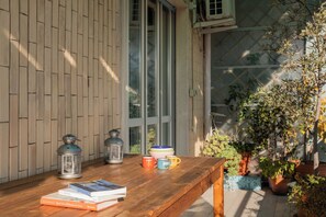 A wooden table with books, a lantern, and a mug. - Adriana Family Apartment by Wonderful Italy (Turin)