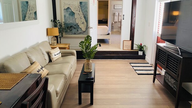 Una sala de estar con sofá, mesa de centro, televisor y un mapa en la pared.