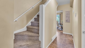 A staircase with carpeted steps leading to a landing. - Mighty Manor (North Battleford)