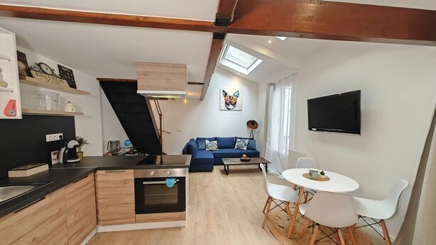 Un espacio habitable pequeño con kitchenette, comedor y sofá.