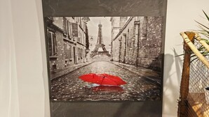 Una obra de arte enmarcada que muestra una calle con la Torre Eiffel al fondo.