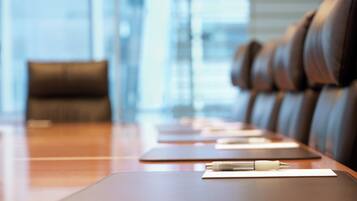 A conference table with leather chairs, a pen, and a notepad.