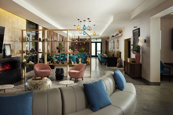 A modern living room with a fireplace, seating area, and a bookshelf.