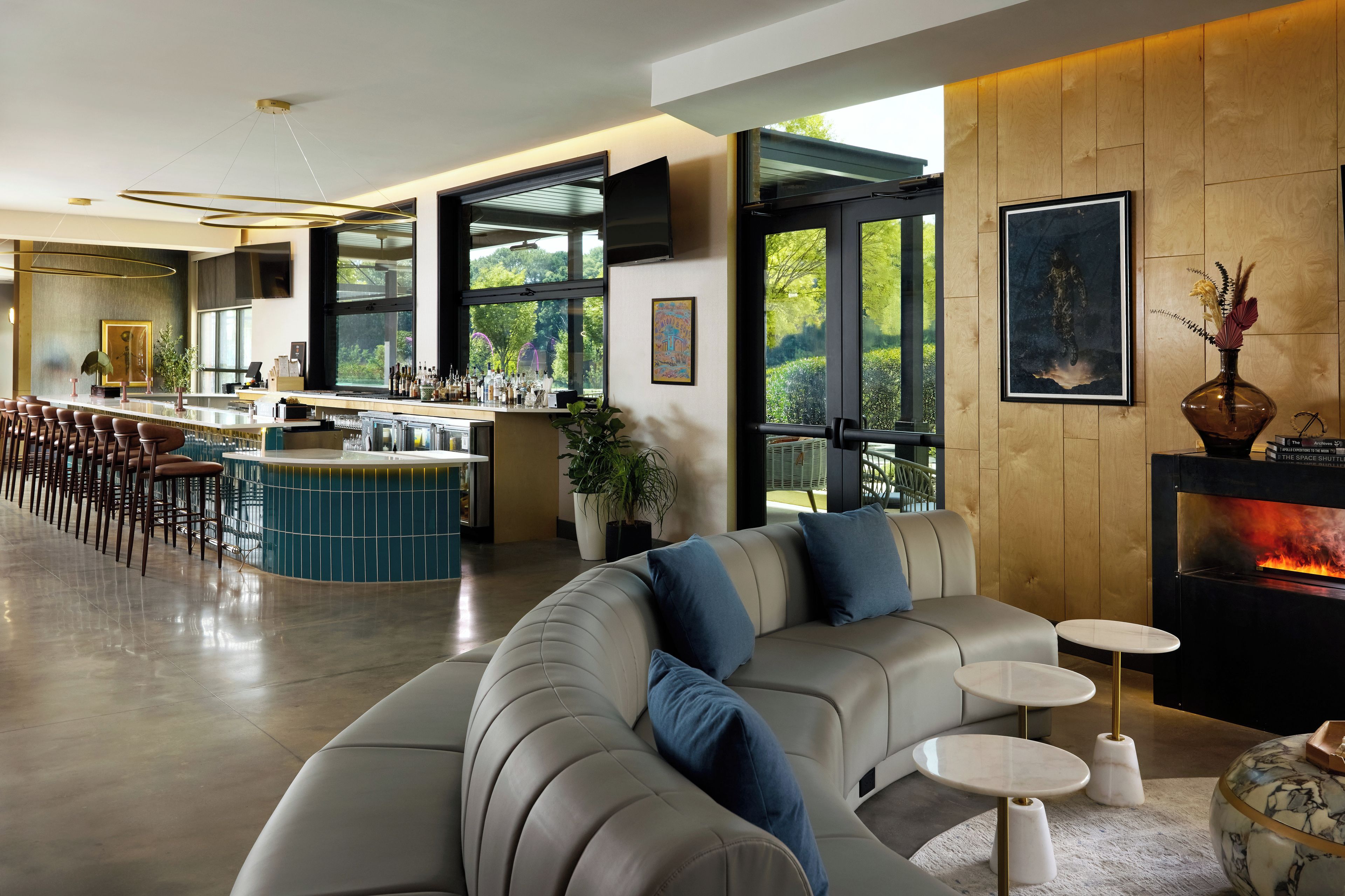 A modern living room with a sofa, a fireplace, and a bar area with stools.