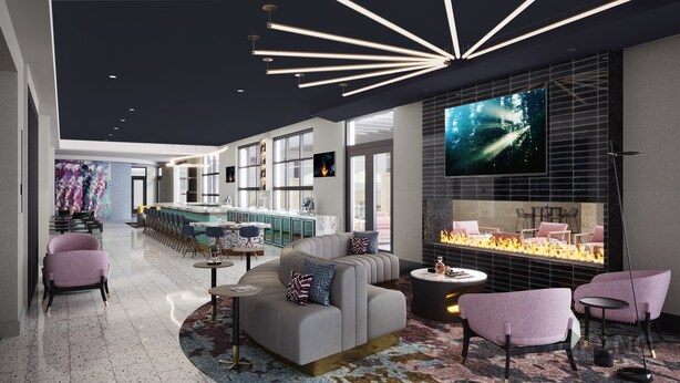 A modern lounge area with a bar, seating, and a fireplace.
