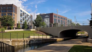 A bridge over a canal with a hotel named 'Hotel Indigo' in the background.
