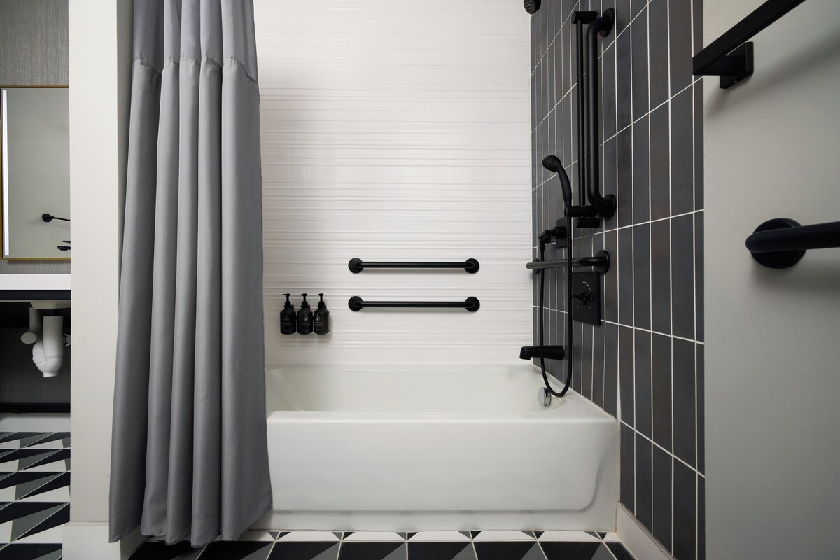Un baño moderno con bañera, ducha e inodoro.