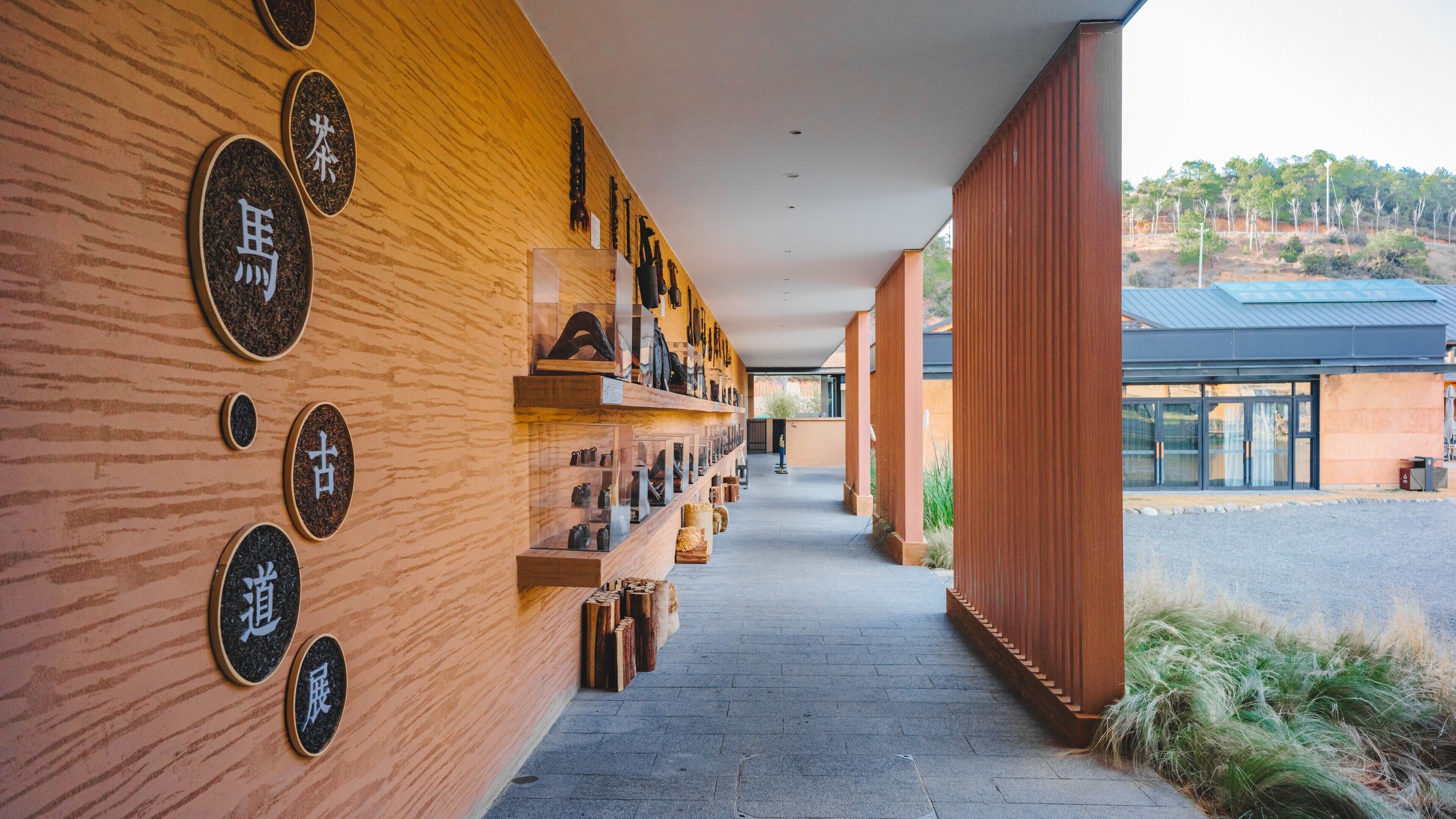 A corridor with wooden walls and shelves displaying various items.