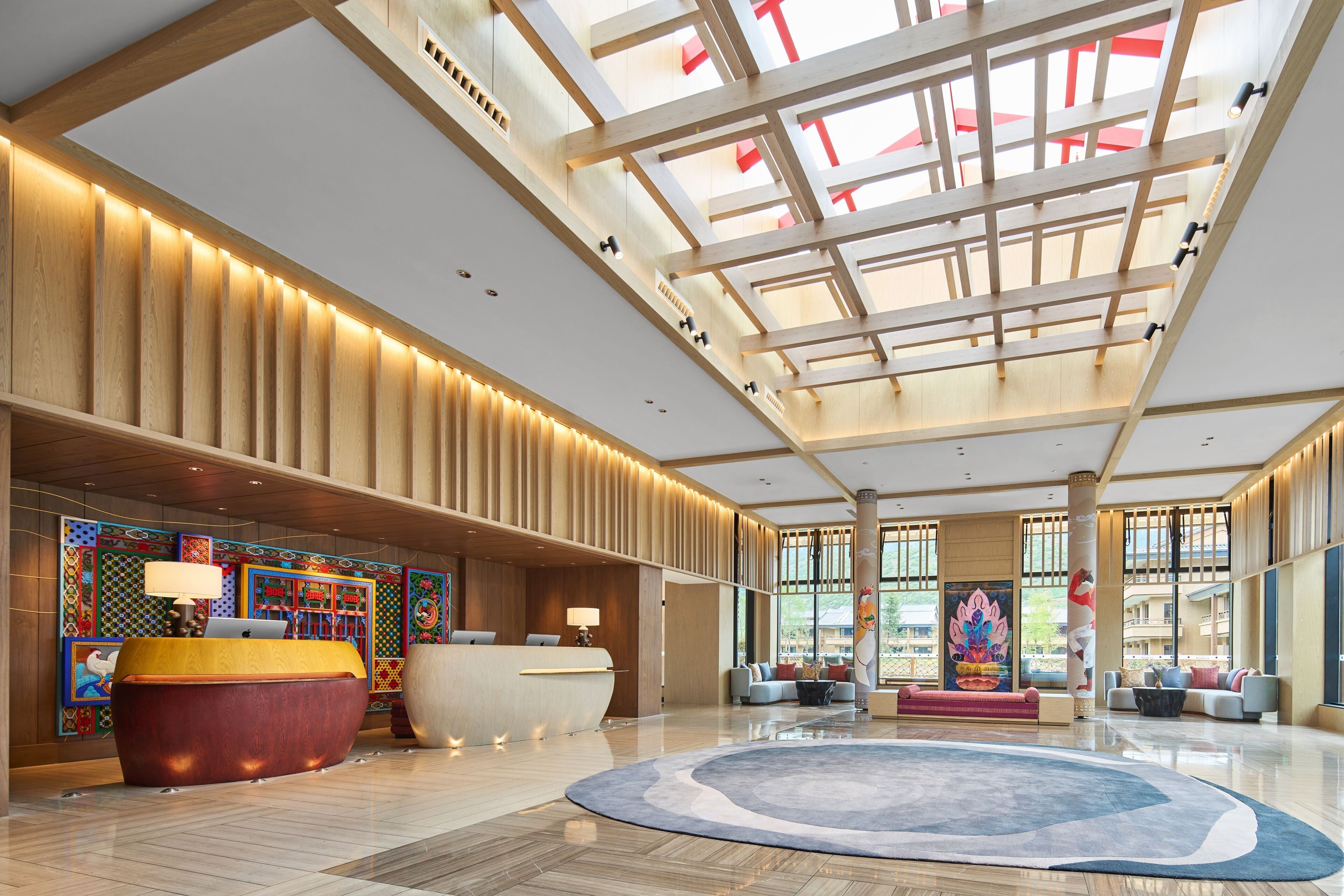 Un'ampia hall con reception, zona relax e grandi vetrate che lasciano entrare la luce naturale.