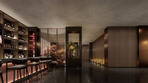 Zona bar moderna con mensole in legno, sgabelli da bar e una pianta decorativa.