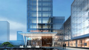 Un edificio moderno con facciata in vetro e un cartello con scritto "CROWNE PLAZA".